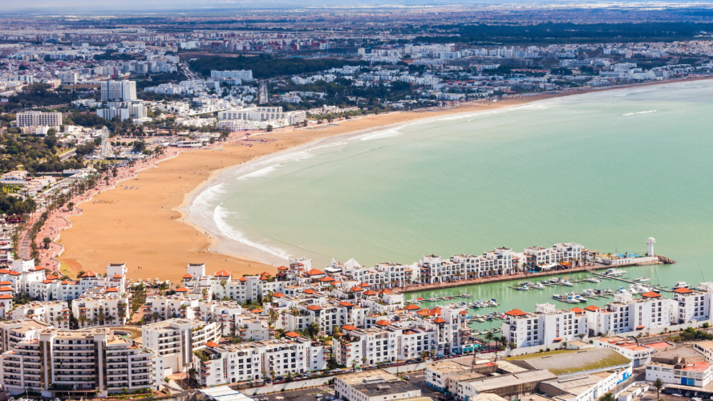 Vue aérienne captivante de la ville d'Agadir, avec ses plages dorées, son architecture harmonieuse, et son mélange unique de tradition berbère et de modernité. Découvrez l'excellence culinaire au cœur de cette cité côtière en réservant votre table avec l'application Venez.ma pour une expérience inoubliable.